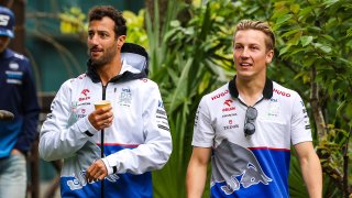 Daniel Ricciardo of Australia and Liam Lawson of New Zealand talk