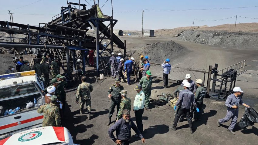 miners and police officers are seen at the site of a coal mine