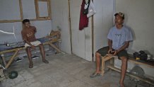 Andika Yudha Agusta, right, and his brother Dias Yudho Prihantoro who work together at a shrimp farm sit inside the hut where they stay during their work shifts at the farm in Kebumen, Central Java, Indonesia, Tuesday, Sept. 24, 2024. (AP Photo/Dita Alangkara)