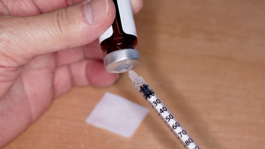 Close up of handheld   needle and syringe with Testosterone Vial