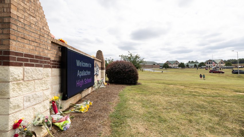 WINDER, GEORGIA – SEPTEMBER 5:  The entrance sign of Apalachee High School adorned with flowers from visitors on September 5, 2024 in Winder, Georgia. Two students and two teachers were shot and killed at the school on September 4, and a 14-year-old suspect, who is a student at the school, is in custody.