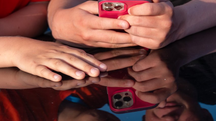 Hands holding phone with pink phone case