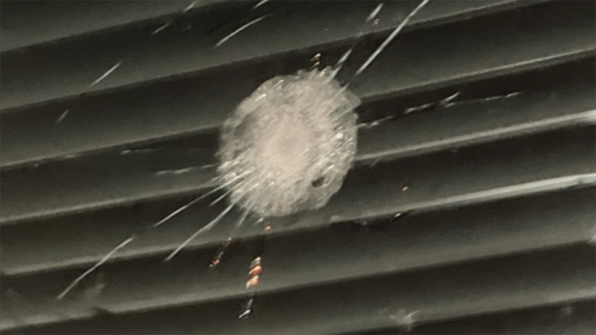 A bullet hole is seen in a window at an apartment complex in southwest Miami-Dade where a 17-year-old was found shot.