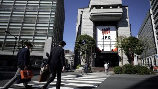 Pedestrians cross a road in front of the Tokyo Stock Exchange (TSE), operated by Japan Exchange Group Inc. (JPX), in Tokyo, Japan, on Thursday, Oct. 29, 2020.