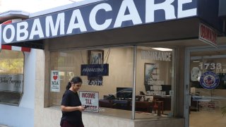 A pedestrian walks past the Leading Insurance Agency, which offers plans under the Affordable Care Act (also known as Obamacare) on January 28, 2021 in Miami, Florida.