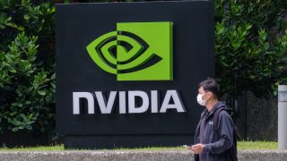 A man wearing a mask walks past a Nvidia logo in Taipei, Taiwan.