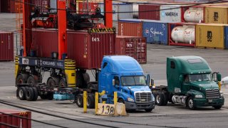 A worker loads a shipping container onto a truck at the Port Authority of New York and New Jersey in, Newark, New Jersey, U.S., September 30, 2024.