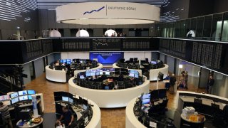 Traders work in front of a board displaying the chart of Germany’s share index DAX at the stock exchange in Frankfurt am Main, western Germany, on September 24, 2024.