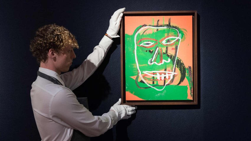 A gallery staff member looks at a painting by Andy Warhol & Jean-Michel Basquiat, Collaboration, 1982-1985, estimate £1,000,000 1,500,000 during a photo call at Christie’s auction house showcasing the highlights of 20th/21st Century Evening Sale in London, United Kingdom on October 06, 2023.