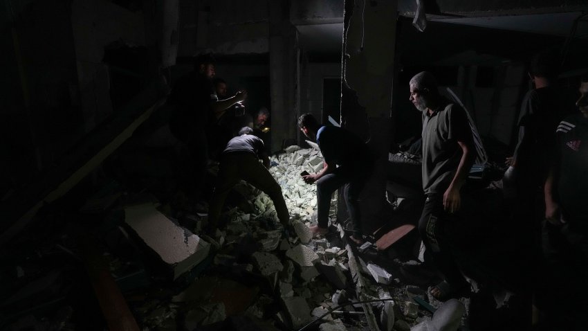 Palestinians search for survivors and bodies in the rubble of a mosque destroyed in an Israeli airstrike in Deir al-Balah, Sunday, Oct. 6, 2024.