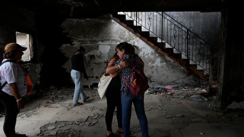 People hug at the house of Maayan and Yuval Bar killed by Hamas, as Israel marks the one-year anniversary of the Hamas attack on Israel, at the Kibbutz Be'eri, an Israeli communal farm on the Gaza border, on Monday, Oct. 7, 2024.