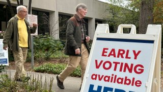 People leave after voting in the Atlanta suburb of Sandy Springs, Ga., on Tuesday, Oct. 15, 2024, the first day of early in-person voting in Georgia.