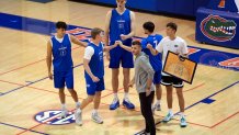 Olivier Rioux, back center, a 7-foot-9 NCAA college basketball player at Florida, gathers with coaches and teammates at the team's practice, Friday, Oct. 18, 2024, in Gainesville, Fla. 