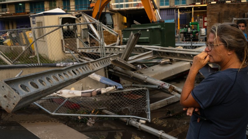 ST. PETERSBURG, FL – OCTOBER 10: Dawn Fader of Treasure Island, Fla. looks at damage from a fallen crane in  downtown St. Petersburg, Fla. on October 10, 2024 after Hurricane Milton came through the Tampa Bay area. Fader was staying at her condo downtown after her Treasure Island home was destroyed by Hurricane Helene. (Photo by Thomas Simonetti for The Washington Post via Getty Images)