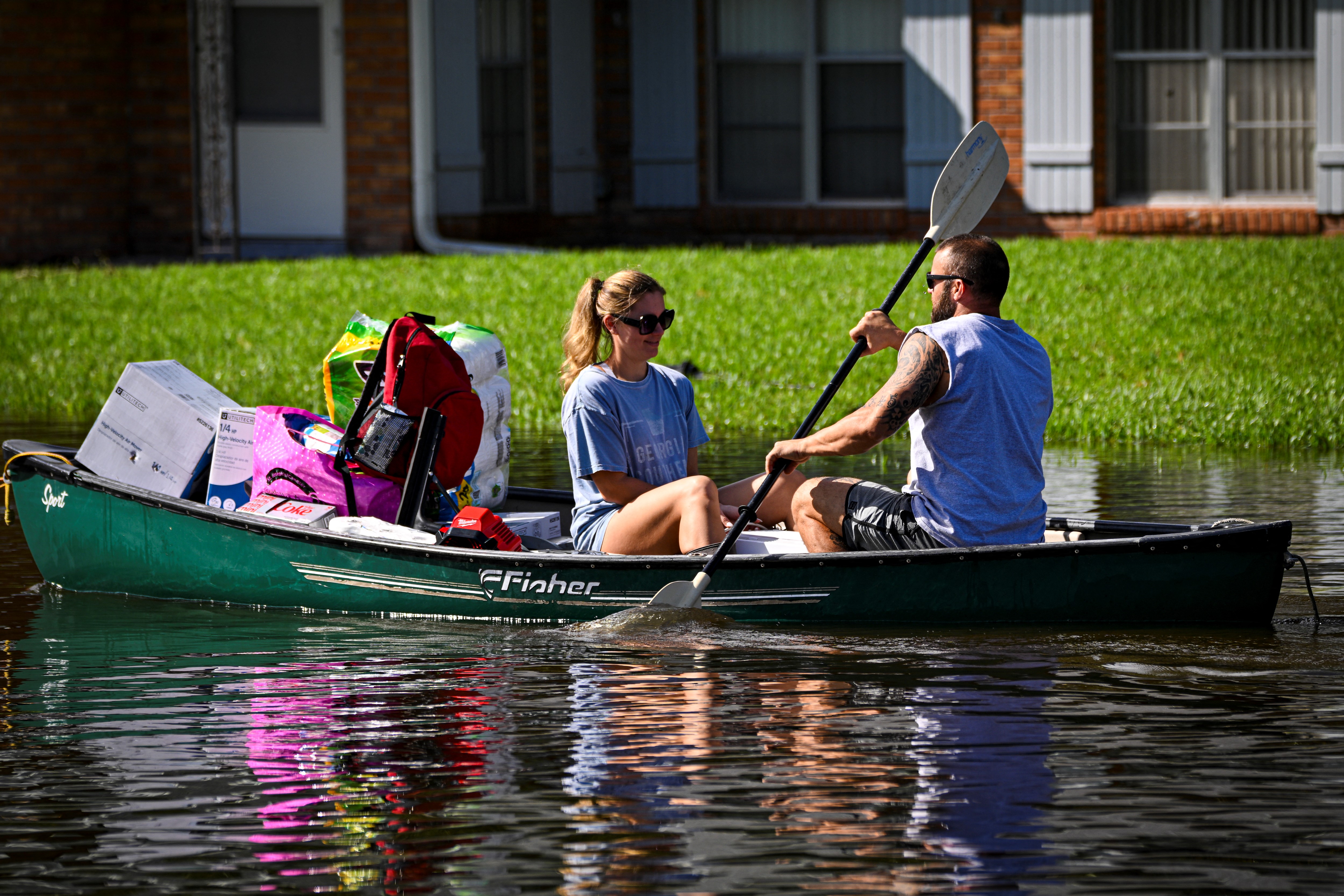 People paddle down a flooded street in South Daytona, Fla, on Oct. 11, 2024.