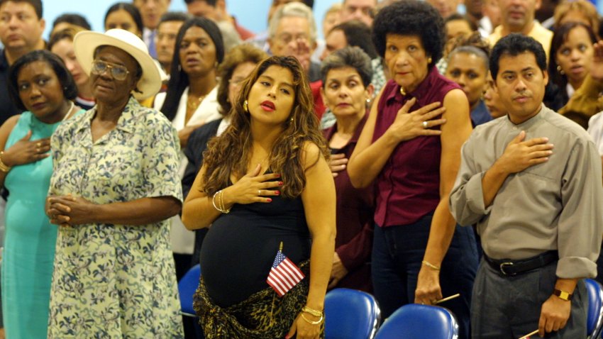 398848 03: (L-R) Silvia Rosllie St. Louis from Haiti, Jessica Hurtado from Peru, Yvonne Hart from Jamaica and Joge Vazquez from Nicaragua place their hands across their hearts as they recite the pledge of allegiance December 19, 2001 after they were sworn in as new U.S. citizens in Miami Beach, Florida. About 4,000 immigrants from 94 countries became citizens in the ceremony. The U.S. Immigration and Naturalization Service expects to grant citizenship to about 800,000 immigrants in the 2001-2002 fiscal year. (Photo by Joe Raedle/Getty Images)