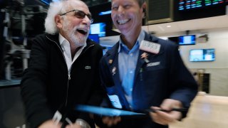 Stock trader Peter Tuchman, left, works on the floor of the New York Stock Exchange.