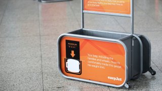 A hand luggage dimension gauge stands beside the Easyjet Plc check-in area at Stansted Airport, operated by Manchester Airports Group (MAG), in London, U.K., on Wednesday, Aug. 7, 2013. 