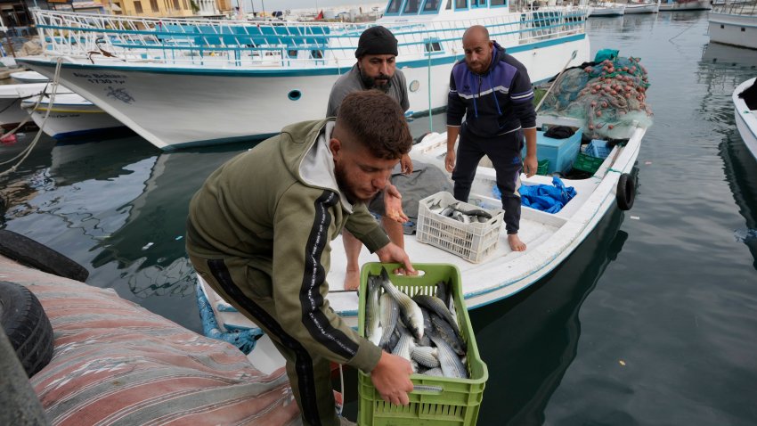 A fisherman holds a basket full of fish