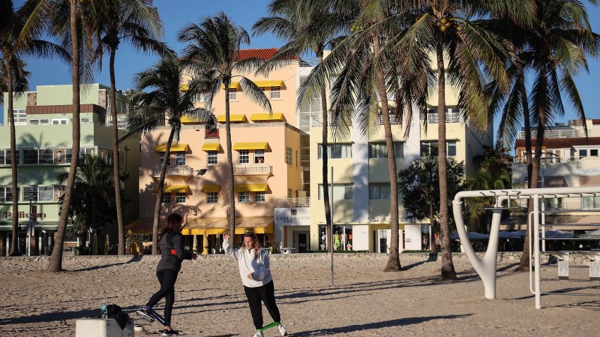 Women exercise together at Muscle Beach South Beach in the cool morning air.  Cool weather arrived in S. Florida with an air temperature of 54 degrees as tourists and locals alike wore their hats, coats, and scarfs while venturing outside on Tuesday, December 8, 2020.  Colder weather is expected to dip into the forties over the weekend. (Carl Juste/Miami Herald/Tribune News Service via Getty Images)