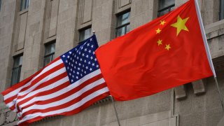 FILE -- The national flags of the United States and China flutter at the Fairmont Peace Hotel on April 25, 2024, in Shanghai, China.