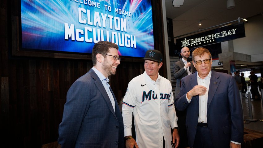 Peter Bendix, president of baseball operations, left, Clayton McCullough, new team manager, center, and Bruce Sherman, principal owner, all talk after a press conference welcoming McCullough to the Miami Marlins on Monday, Nov. 18, 2024, at loanDepot Park in Miami. (Alie Skowronski/Miami Herald/Tribune News Service via Getty Images)