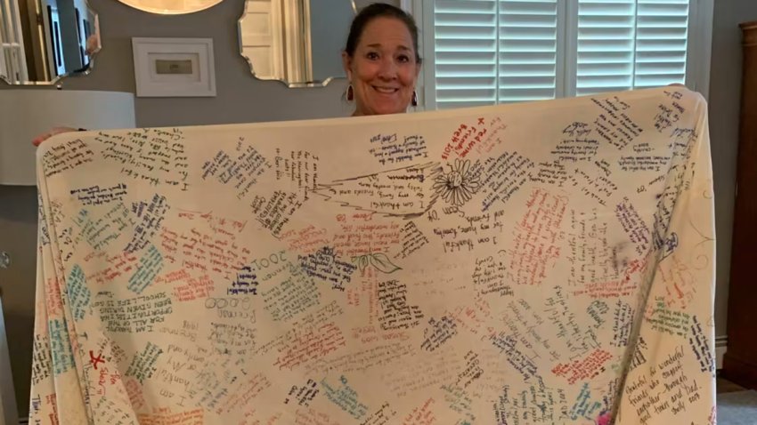 Caroline Harrington holds her Thanksgiving gratitude tablecloth.