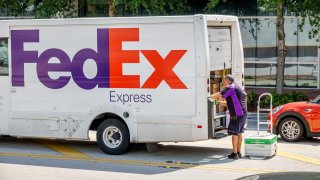 Miami Beach, Florida, FedEx Express delivery van parked, driver unloading box dolly.