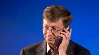 Bill Gates, holding a Palm Treo smartphone during a press conference in 2005.