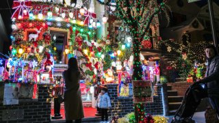 People look at homes decorated with Christmas lights and ornaments in Dyker Heights neighborhood, Brooklyn, New York City on December 20, 2023.