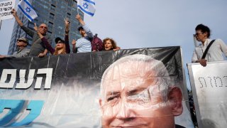 Supporters of Israel’s Prime Minster Benjamin Netanyahu, seen in poster, gather outside a  court in Tel Aviv, Israel, Tuesday, Dec. 10, 2024 as Netanyahu is set to take the stand in his long-running trial on corruption charges.