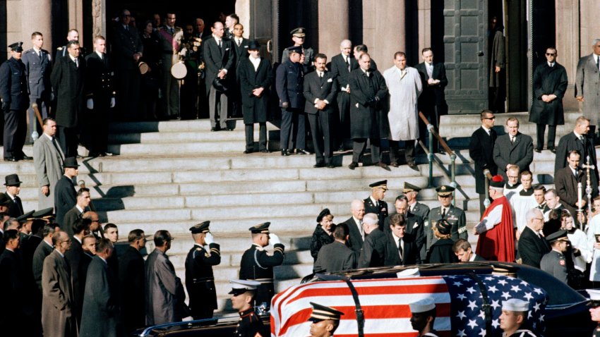 FILE - A general view outside St. Matthew's Cathedral in Washington, D.C., during President John F. Kennedy's funeral, with flag-draped coffin in the foreground, Nov. 25, 1963. The president's brothers can be seen behind the casket. At left is Sen. Edward M. Kennedy (D-Mass.), and at right entering limousine is Attorney General Robert F. Kennedy.