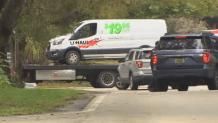 A U-Haul van is towed from the scene in Coral Gables where authorities believe a possible human smuggling ring was busted.