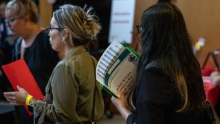 A jobseeker holds flyers during the New York Public Library’s annual Bronx Job Fair & Expo at the the Bronx Library Center in the Bronx borough of New York, on Sept. 6, 2024.
