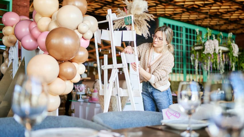 An event coordinator arranges decorations for a child’s birthday party.