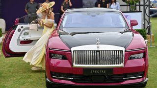 A guests gets out of a Rolls Royce Spectre during the Salon Prive Concours 2024 at Blenheim Palace on August 28, 2024 in Woodstock, England.