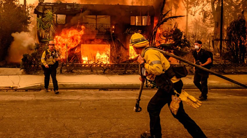 Firefighters work the scene as an apartment building burns during the Eaton fire in the Altadena area of Los Angeles county, California on January 8, 2025.