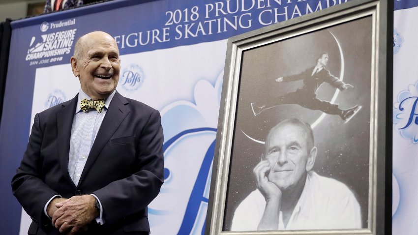 Dick Button smiles next to a painting of him while honored at the U.S. Figure Skating Championships in San Jose, Calif., Thursday, Jan. 4, 2018.