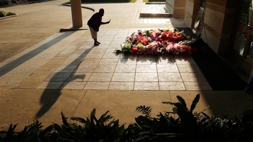 FILE - A woman stops to photograph a memorial for George Floyd