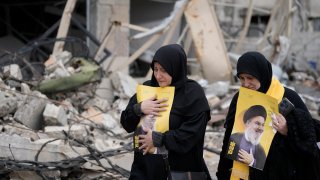Lebanese women hold portraits of of slain Hezbollah leader Sayyid Hassan Nasrallah