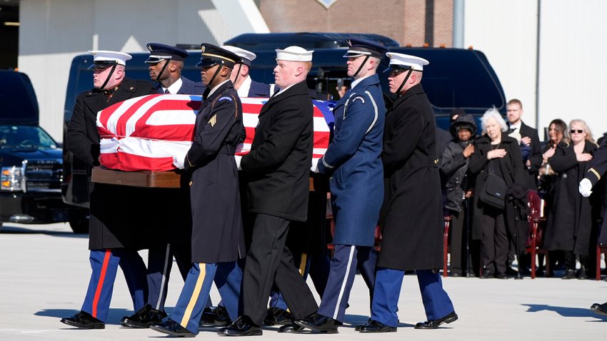 A joint forces military body bearer team moves flag-draped casket of former President Jimmy Carter to Special Air Mission 39 at Dobbins Air Reserve Base in Marietta, Ga., Tuesday, Jan. 7, 2025. Carter died Dec. 29 at the age of 100.