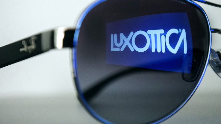 The EssilorLuxottica SA logo is reflected in the lens on a pair of Ray-Ban sunglasses in this arranged photoraph inside a Pearle opticians store, operated by GrandVision NV, in Amsterdam, Netherlands, on Wednesday, July 1, 2020. EssilorLuxottica, the maker of Ray-Ban sunglasses, remains committed to its proposed 7.3 billion-euro ($8.3 billion) purchase of retailer GrandVision NV, people with knowledge of the matter said. Photographer: Peter Boer/Bloomberg via Getty Images