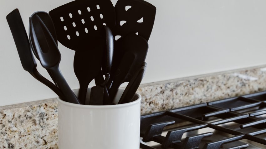 Close-up view of cooking utensils in container on kitchen counter.