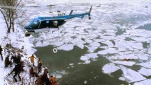 Rescue workers wait on the bank of the Potomac River to aid survivors of the Air Florida jet crash. The 737 was taking off from Washington National Airport en route for Tampa when it collided into a bridge jammed with rush-hour commuters.