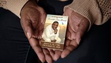 Widow Sharline Volcy holds a picture of her deceased