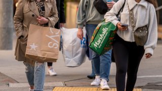 Shoppers carry Macy’s, Marshalls, and Ross bags on Post Street in San Francisco, California.