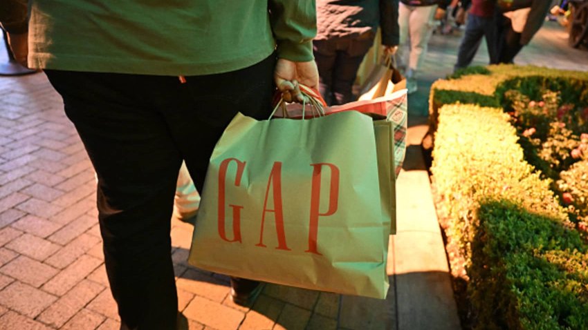 A shopper carries her early Black Friday purchases on Thanksgiving Day, November 28, 2024, at the Citadel Outlets shopping center in Los Angeles. 