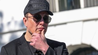 Tesla CEO Elon Musk watches as President Donald Trump talks to the media, outside the White House in Washington, D.C., March 11, 2025.