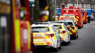 Police vehicles and fire engines are seen near the scene where a fire broke out at a substation supplying power to Heathrow Airport in Hayes, west London on March 21, 2025.
