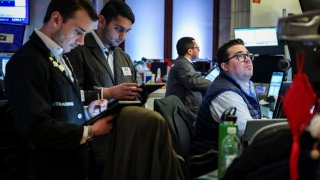 Traders work on the floor at the New York Stock Exchange on March 24, 2025.